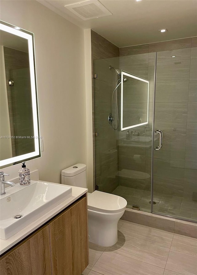 bathroom with vanity, an enclosed shower, tile patterned floors, and toilet