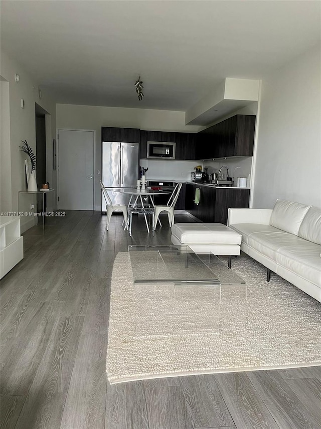 living room with hardwood / wood-style flooring and sink