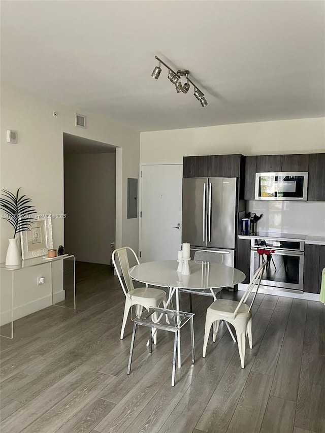 dining space with electric panel and light wood-type flooring