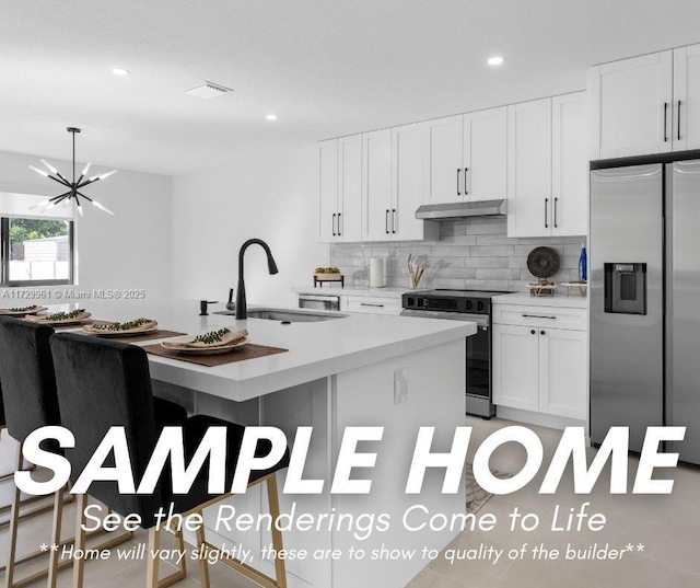 5209 SW 22nd St, West Park, FL 33023 - kitchen featuring backsplash, under cabinet range hood, light countertops, appliances with stainless steel finishes, and a sink