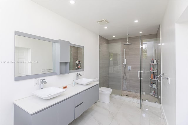 bathroom featuring vanity, toilet, and a shower with door