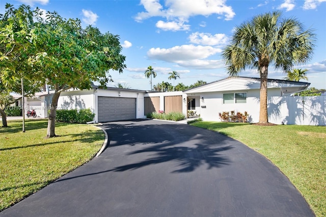 ranch-style home featuring a garage and a front lawn