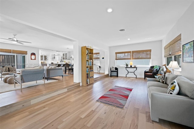 living room with ceiling fan and light wood-type flooring