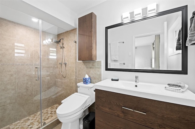 bathroom with vanity, a shower with shower door, and toilet