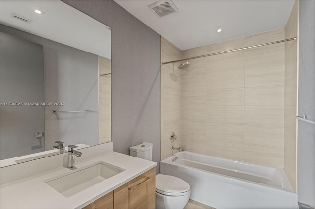 full bathroom with vanity, tiled shower / bath combo, and toilet