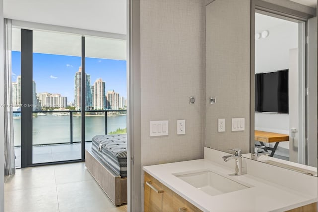 bathroom featuring a water view, tile patterned floors, floor to ceiling windows, and vanity