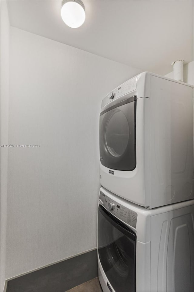 clothes washing area featuring stacked washer and dryer