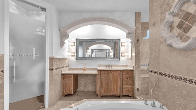 bathroom with vanity, independent shower and bath, and tile walls