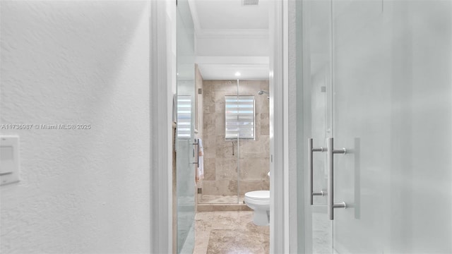 bathroom with ornamental molding, a shower with shower door, and toilet