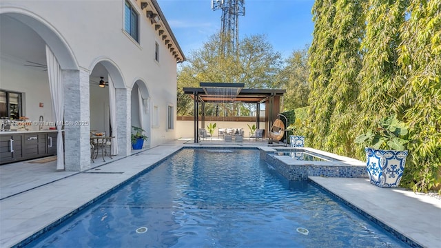 view of swimming pool with ceiling fan, outdoor lounge area, a patio, a bar, and an in ground hot tub