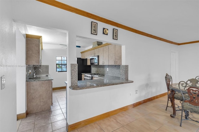 kitchen with crown molding, black refrigerator, dark stone countertops, tasteful backsplash, and gas range