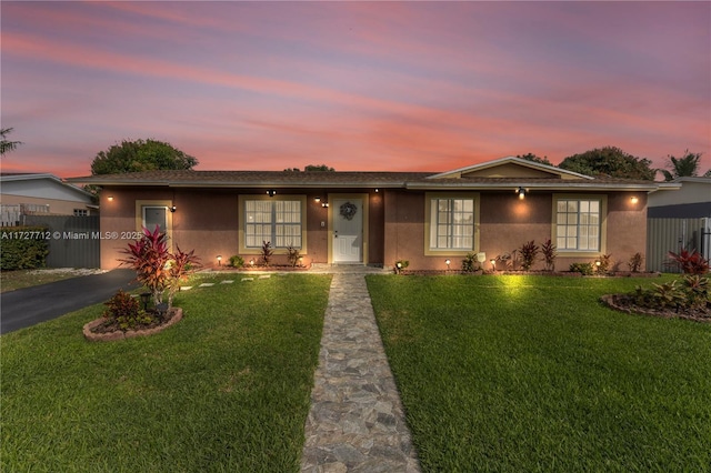 ranch-style home with a yard