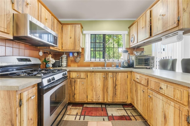 kitchen featuring appliances with stainless steel finishes, sink, and backsplash