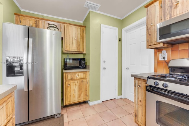 kitchen with light tile patterned flooring, stainless steel appliances, crown molding, and decorative backsplash