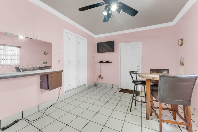 tiled dining space with ornamental molding and ceiling fan