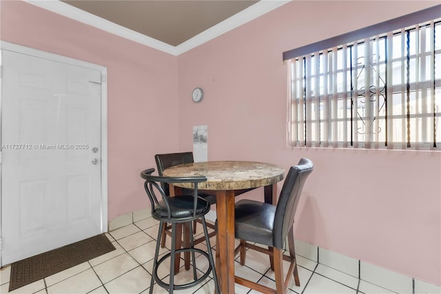 tiled dining room featuring crown molding