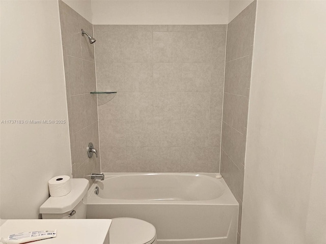 full bathroom with tiled shower / bath, vanity, and toilet