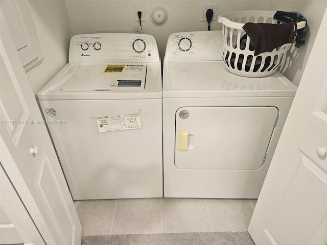 clothes washing area featuring washing machine and clothes dryer and light tile patterned floors