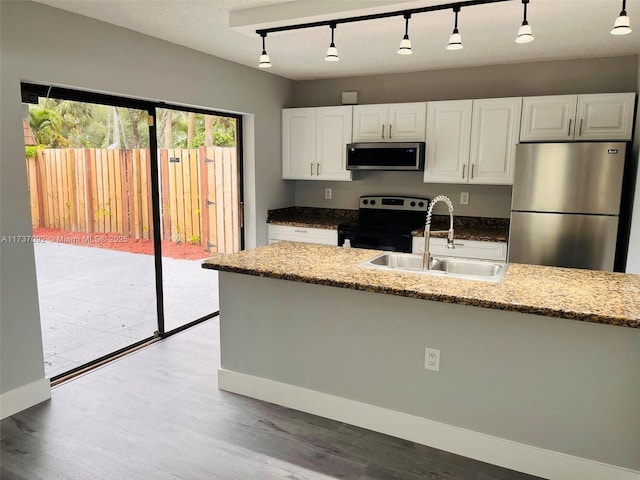 kitchen with sink, light wood-type flooring, appliances with stainless steel finishes, light stone countertops, and white cabinets