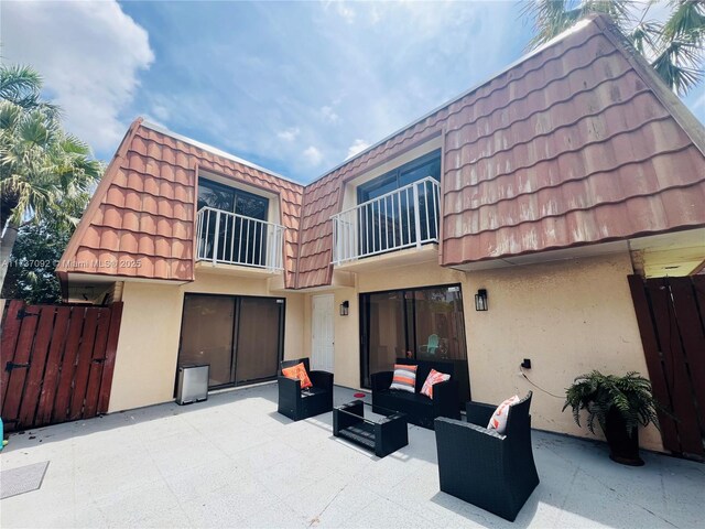 529 Green Springs Pl, West Palm Beach, FL 33409 - back of house with outdoor lounge area, a patio, stucco siding, and mansard roof