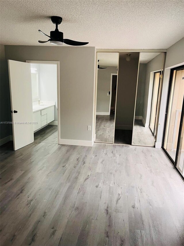 spare room featuring ceiling fan, a textured ceiling, and light wood-type flooring