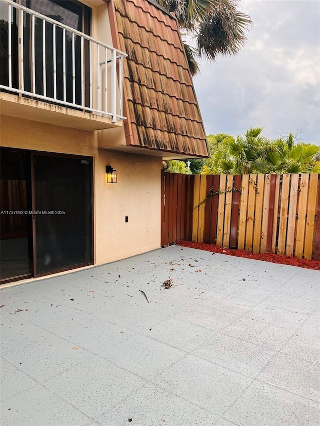 view of side of property with a balcony and a patio