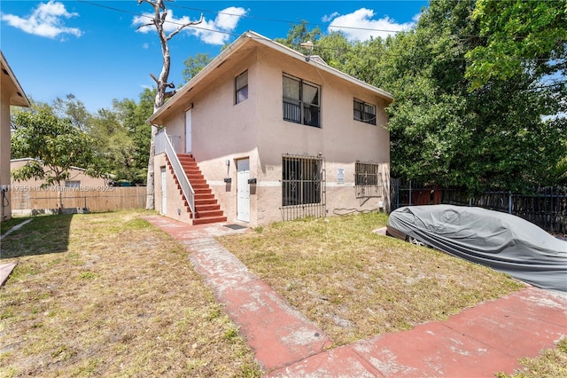 rear view of house featuring a yard