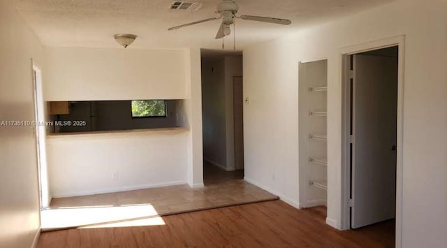 unfurnished room with hardwood / wood-style floors, a textured ceiling, and ceiling fan