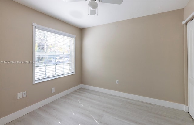 spare room with light wood-type flooring and ceiling fan