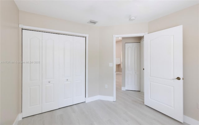 unfurnished bedroom featuring light hardwood / wood-style floors and a closet