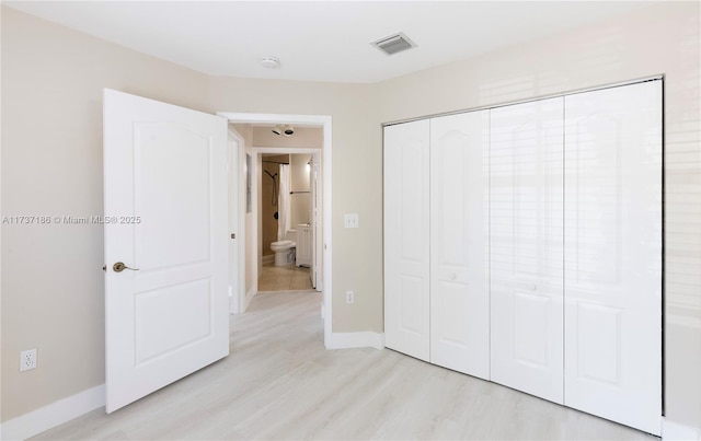 unfurnished bedroom featuring light hardwood / wood-style flooring and a closet