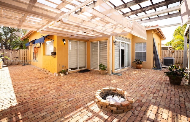 view of patio / terrace featuring a pergola, a fire pit, and central air condition unit