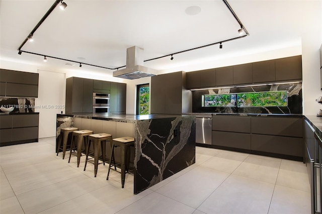 kitchen with tasteful backsplash, a breakfast bar area, dark brown cabinetry, and track lighting