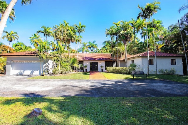 14135 N Miami Ave, Miami, FL 33168 - view of front of house with driveway, stucco siding, a front yard, and a tiled roof
