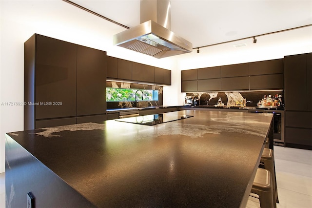 kitchen with black electric stovetop, island exhaust hood, modern cabinets, a breakfast bar area, and a spacious island