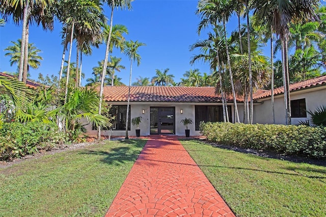 14135 N Miami Ave, Miami, FL 33168 - view of front of house featuring stucco siding, a tiled roof, and a front lawn