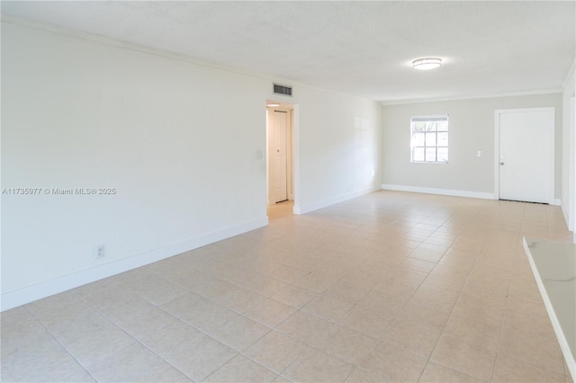 spare room featuring ornamental molding and a textured ceiling