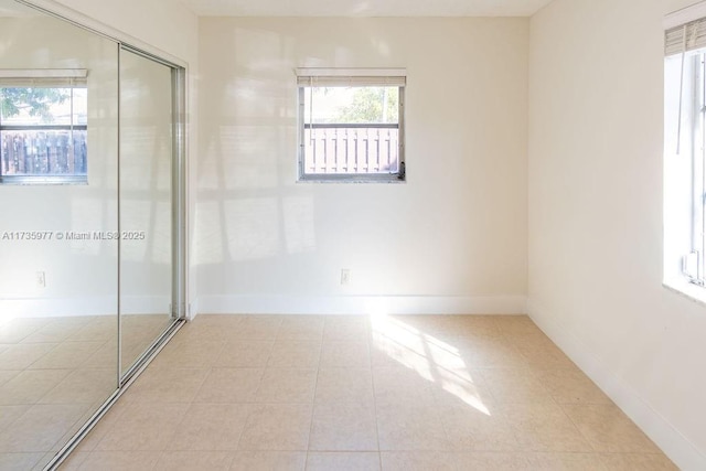 unfurnished bedroom featuring light tile patterned floors and a closet