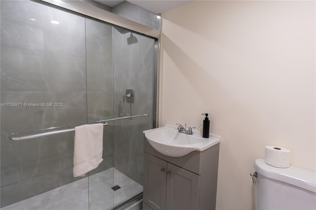 bathroom featuring vanity, toilet, and a shower with door