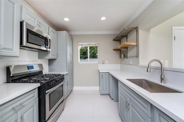 kitchen featuring gray cabinetry, sink, ornamental molding, and stainless steel appliances