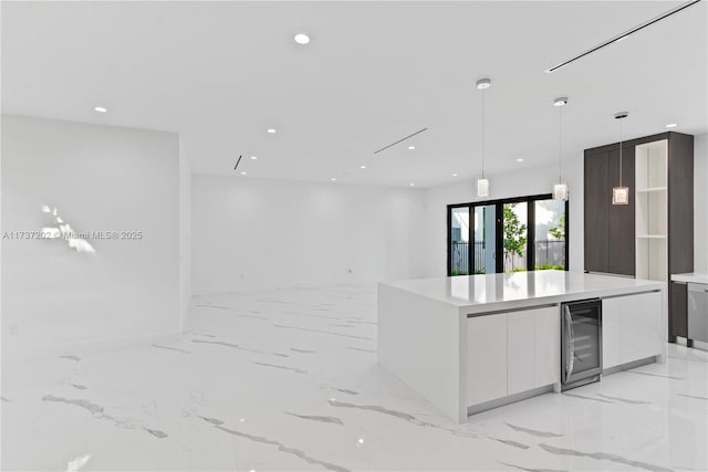 kitchen with white cabinetry, beverage cooler, a center island, and pendant lighting