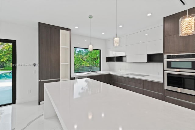 kitchen with pendant lighting, sink, white cabinetry, and black electric cooktop