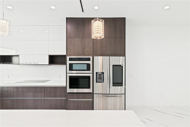 kitchen with dark brown cabinetry, a chandelier, appliances with stainless steel finishes, pendant lighting, and white cabinets