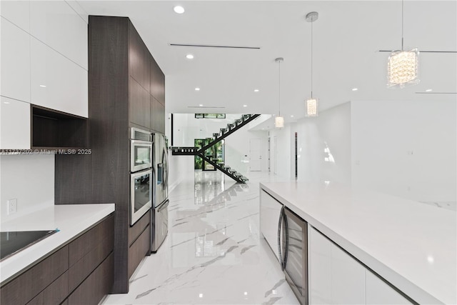 kitchen with appliances with stainless steel finishes, wine cooler, white cabinets, hanging light fixtures, and dark brown cabinets