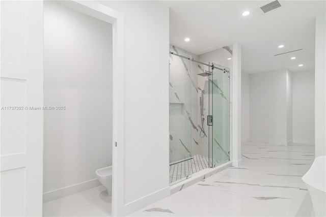 bathroom featuring a shower with shower door and toilet