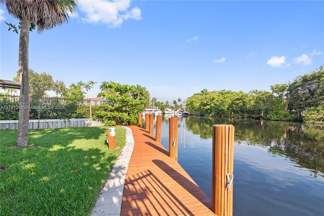 dock area featuring a water view and a lawn