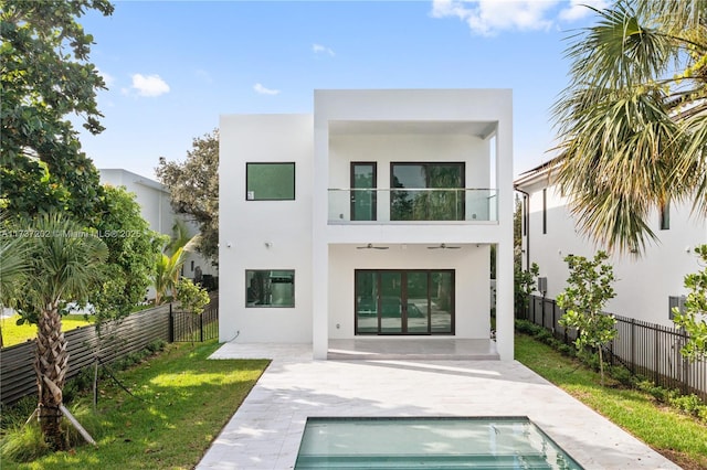 back of property with a fenced in pool and a patio area