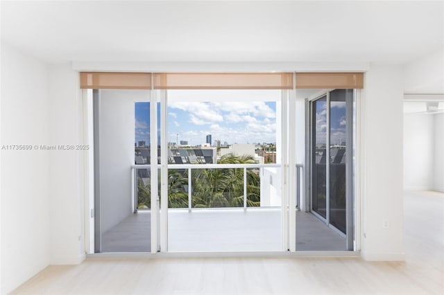 unfurnished room featuring expansive windows and light hardwood / wood-style floors