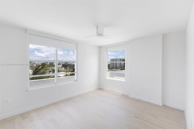 unfurnished room featuring light hardwood / wood-style flooring, a wealth of natural light, and ceiling fan