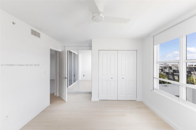 unfurnished bedroom with ceiling fan and light wood-type flooring